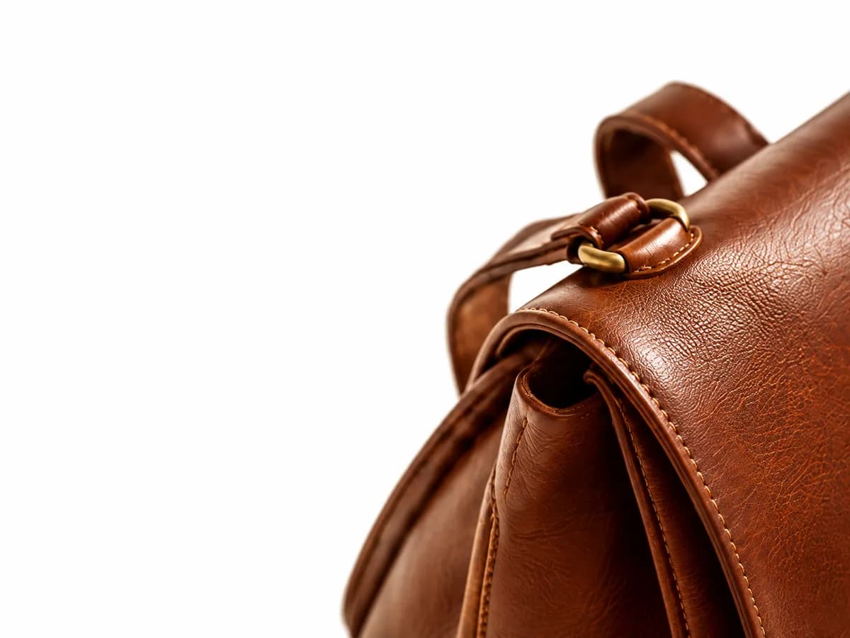 Close-up of the brass ring and stitching on a tan leather bag